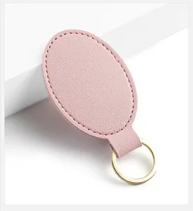 Vista detallada de llavero de cuero PU rosa con anillo dorado, diseño minimalista.