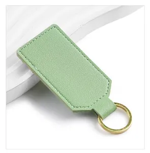 Light green PU leather keychain with white stitching and gold metal ring, minimalist style detail.