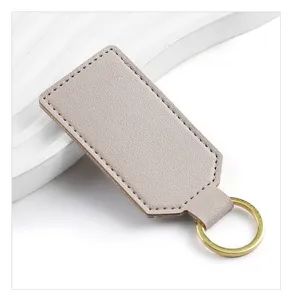 Detailed view of grey PU leather keychain with brass keyring and neat stitching closeup