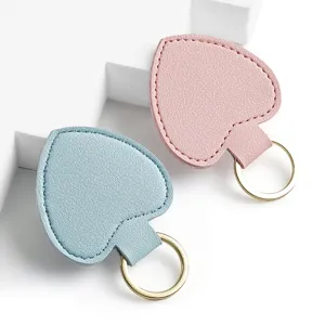 Herzförmiger Leder Schlüsselanhänger Taschenanhänger Set in Blau und Rosa mit goldenem Ring.
