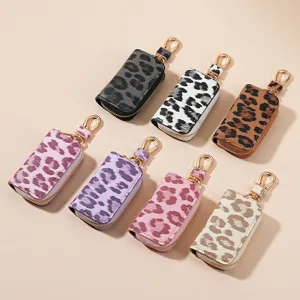 Étui de clé de voiture en cuir léopard tendance avec fermeture éclair et anneau doré.