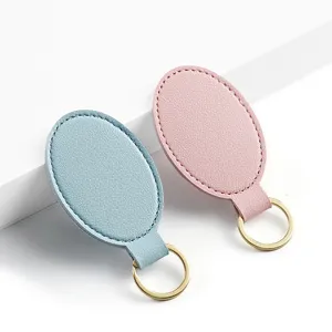 Llavero ovalado de piel sintética PU minimalista en azul y rosa con anilla dorada, vista principal