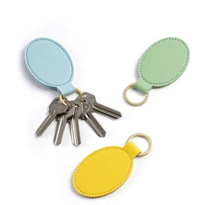 Set de llaveros de cuero PU con diseño ovalado y anillas metálicas en diferentes colores.