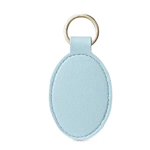 Llavero ovalado de piel sintética azul claro con anillo metálico dorado, elegante.