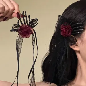 Detail view of gothic skeleton hand hair clip featuring burgundy rose and black lace