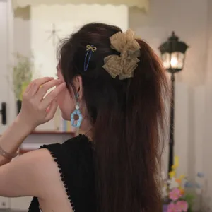 Close-up of an elegant floral mesh bubble banana hair clip styled in a high ponytail