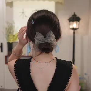 Delicate mesh floral banana clip hair accessory shown on a stylish low bun hairstyle.