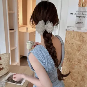 Pinza beige para el pelo con lazo de malla a cuadros en una trenza en una cafetería