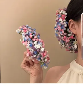 Detailed macro view of vibrant gypsophila floral hair pins for bridal fashion styling