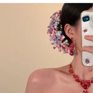 Close-up of elegant floral hairpin and matching red gemstone bridal jewelry set