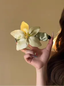 Nahaufnahme einer eleganten handgefertigten gelben Blumen-Haarklammer aus Seide