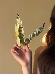 Nahaufnahme der eleganten grünen Satin-Bananenspange mit gelber Blume