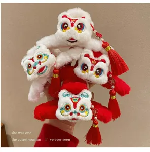 Detalle de pinzas para el cabello de peluche danza del león con borlas rojas