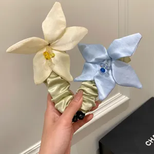 Detailansicht von eleganten handgefertigten Satin-Blumen-Bananenspangen in Weiß und Blau