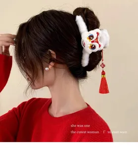 Primer plano de pinza de pelo de león festivo con borla de seda roja