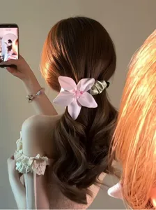 Detail eines eleganten Haarschmucks mit rosa Stoffblume an der Frisur einer Frau