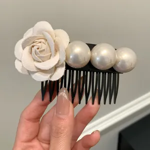 Elegant hair comb featuring a white fabric flower and three large glossy pearls.