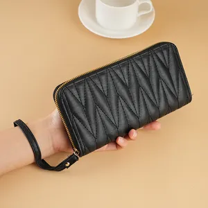 Black quilted long wallet for women with zipper closure and wrist strap, classic chic design.