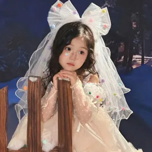 Elegant white children's princess birthday veil featuring colorful pompoms and a large mesh bow