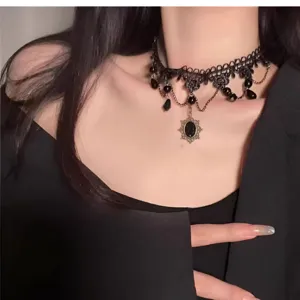 Primer plano detallado de un choker gótico de encaje negro con colgante de gema.