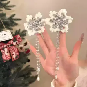 Close-up of white snowflake hair clips with sparkling rhinestones and pearl tassels.
