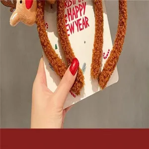 Close-up detail of a soft plush reindeer headband displayed on a festive holiday card