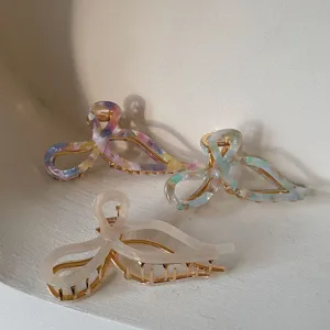 Elegant set of acetate bow hair claw clips in vibrant marbled colors and creamy white