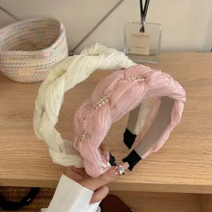 Gedetailleerde weergave van Franse gevlochten haarbanden met elegante parel- en strass-accenten