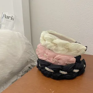Gedetailleerd overzicht van elegante gevlochten geplooide haarbanden met parels en kristallen