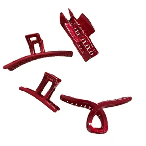 Set de cuatro pinzas para el cabello grandes y rojas brillantes sobre fondo blanco
