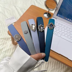 Close-up of elegant blue and grey sponge headbands with various rhinestone details.