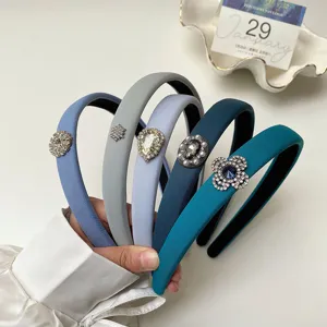 Elegant handheld collection of blue and grey padded headbands with rhinestone flower accents