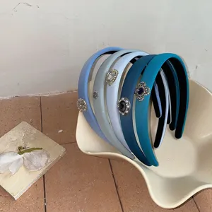 Detailed view of blue-grey gradient padded headbands with rhinestone floral embellishments