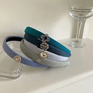 Close-up of padded blue-gray fabric headbands with assorted rhinestone embellishments