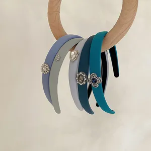 Detail view of assorted blue and gray padded headbands with elegant rhinestone accents.