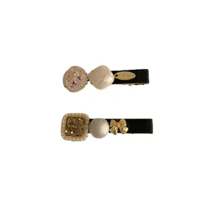 Elegant vintage pearl and rhinestone duckbill hair clips set on black velvet base.