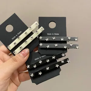 Dettaglio di fermagli per capelli con stelle in crema, grigio e nero