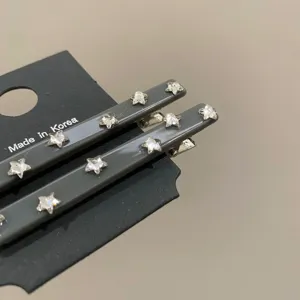 Dettaglio di fermagli per capelli grigi con decorazioni di strass a forma di stella