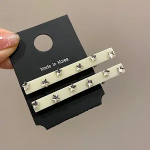 Primo piano dettagliato di due fermagli per capelli crema con strass a forma di stella