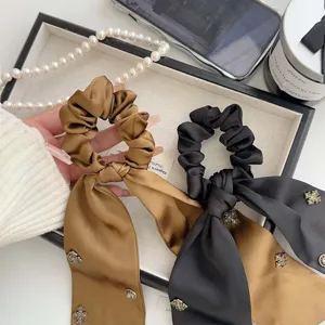 Eleganti scrunchies in raso stile francese dotati di nastri lunghi e strass