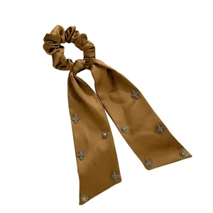 Elegante scrunchie in raso marrone con nastro lungo e decorazioni metalliche brillanti