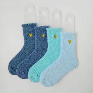 Detaillierte Nahaufnahme weicher Korallenvlies-Socken in Blautönen mit goldenen Herzen