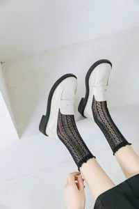 Dettaglio di calze JK in pizzo nero stile Lolita indossate con mocassini bianchi