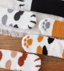 Nahaufnahme von flauschigen Korallenvlies-Socken mit niedlichen Katzenpfotenmustern