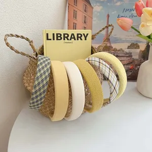 Set of yellow series wide headbands with various textures and plaid patterns in a woven basket