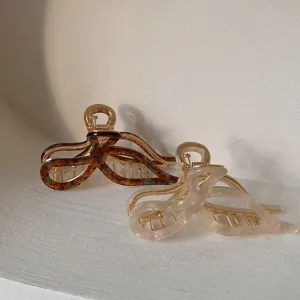 Elegant acetate and alloy bow-shaped shark hair clips in tortoiseshell and pearl white