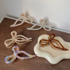 Elegant acetate bow hair claws in various marbled and tortoiseshell patterns set.
