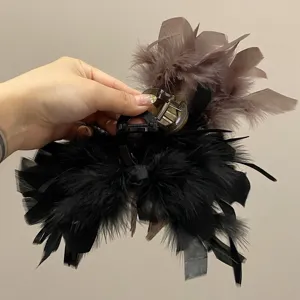 Detail view of elegant ostrich feather hair claw clips in black and mauve colors