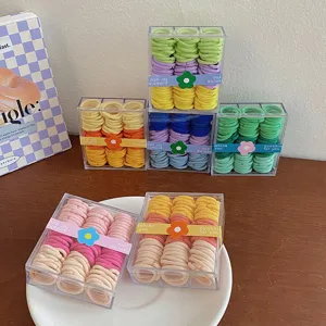 Vista detallada de mini gomas para el pelo de colores en cajas de almacenamiento