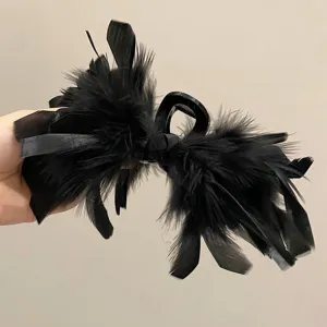 Detailed view of a large black ostrich feather hair claw clip for elegant styling